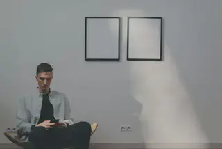 Man witting in front of wall
